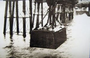 Diving bell with the men who worked inside to prepare the sea bed being lowered into the sea by a crane . Dover Transport Museum