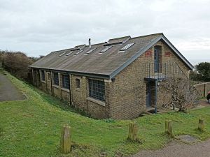One of the two former Prison buildings at Langdon Cliff that are still standing. The plaques give date of construction in 1902 and refurbishment in 1995. A Sencicle