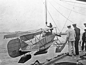 Short Folder seaplane (S.64), serial number 81, being hoisted out from the Royal Navy ship Hermes with wings folded. wikimedia commons